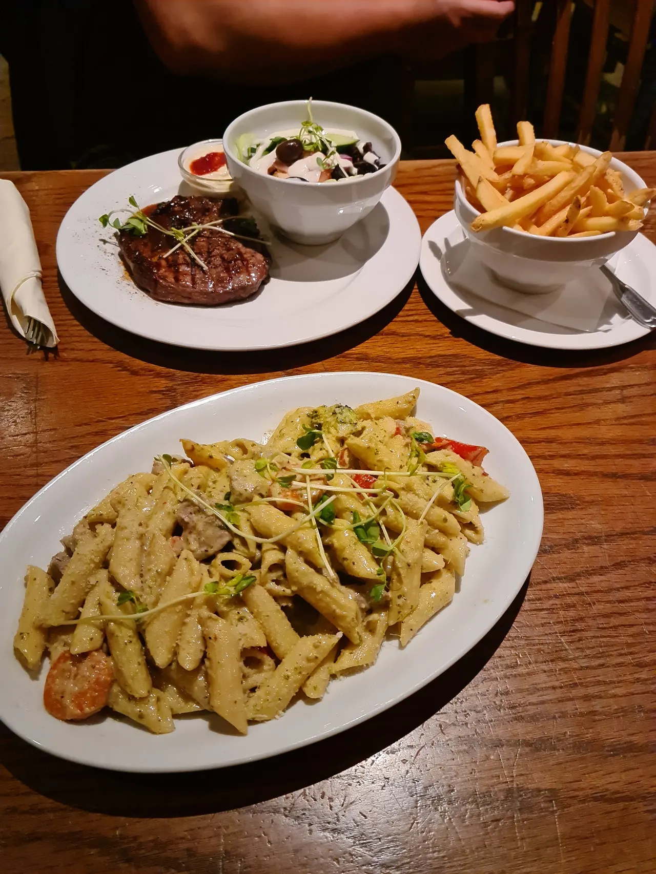 Biff, pasta och pommes dukat på trädbord hos Tiffany's